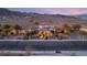 Elegant desert home with illuminated landscaping, palm trees, and views of distant mountains at 942 Villa Grande Way, Boulder City, NV 89005
