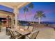 Elegant covered patio with dining and fire pit overlooking the pool and beautiful desert scenery at 942 Villa Grande Way, Boulder City, NV 89005