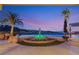 Stunning pool area with a beautiful dolphin fountain, inviting lounge chairs, and tropical palm trees at 942 Villa Grande Way, Boulder City, NV 89005