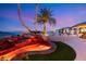 Stunning outdoor water feature with colorful lights, lush palm trees, and cascading rocks at 942 Villa Grande Way, Boulder City, NV 89005