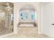 Bathroom with a soaking tub and three windows overlooking the yard at 10117 Summit Canyon Dr, Las Vegas, NV 89144