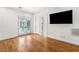 Bedroom featuring wood floors, bright white walls, and a large mounted television at 10117 Summit Canyon Dr, Las Vegas, NV 89144