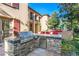 Well-equipped outdoor kitchen with stainless steel grill and stone surround at 10117 Summit Canyon Dr, Las Vegas, NV 89144