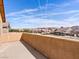 A balcony overlooking the neighborhood with a decorative wall and mountain views under a blue sky at 1012 Water Cove St, Henderson, NV 89011