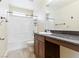 Bright bathroom featuring a shower-over-tub, toilet and vanity with dark countertop at 1012 Water Cove St, Henderson, NV 89011