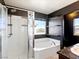 Bathroom featuring a shower, tub, and floating shelves with a window offering an outside view at 1012 Water Cove St, Henderson, NV 89011