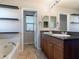 Bathroom featuring dual sinks, a soaking tub, and a large mirror, offering a functional and elegant design at 1012 Water Cove St, Henderson, NV 89011