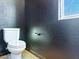 This is a half bathroom with a toilet and a wall finished in a dark, reflective paint at 1012 Water Cove St, Henderson, NV 89011