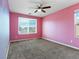 Spacious pink bedroom featuring a ceiling fan and carpeted floors at 1012 Water Cove St, Henderson, NV 89011