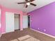 Bedroom featuring neutral carpet, a closet, and painted pink and purple walls, creating a stylish atmosphere at 1012 Water Cove St, Henderson, NV 89011