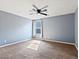 Empty bedroom featuring carpet floors, gray walls, a ceiling fan, and a window for natural light at 1012 Water Cove St, Henderson, NV 89011