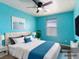 Stylish bedroom with blue walls, ceiling fan, large window, and tastefully decorated with furniture at 1012 Water Cove St, Henderson, NV 89011