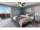 Comfortable staged main bedroom with a ceiling fan, balcony access, and large window providing ample natural light at 1012 Water Cove St, Henderson, NV 89011