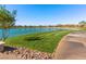 Scenic view of the community pond surrounded by manicured grass, walking path, and beautiful landscaping at 1012 Water Cove St, Henderson, NV 89011