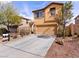 Two-story tan home with a concrete driveway and desert landscaping in a residential neighborhood at 1012 Water Cove St, Henderson, NV 89011