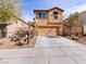 Two-story home with a tandem garage, a xeriscaped front yard and concrete driveway at 1012 Water Cove St, Henderson, NV 89011