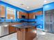 Kitchen featuring an island with granite countertops, tile floors, stainless steel appliances, and wood cabinets at 1012 Water Cove St, Henderson, NV 89011