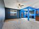 Spacious living room featuring neutral carpet, a ceiling fan, and bright blue accent walls at 1012 Water Cove St, Henderson, NV 89011