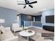 Comfortable staged living room with a ceiling fan, stylish furniture, and staircase access to the second floor at 1012 Water Cove St, Henderson, NV 89011