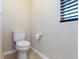 Neat powder room featuring a white toilet and a window, providing a simple and functional space at 1012 Water Cove St, Henderson, NV 89011