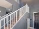 Modern staircase with white railings, carpeted steps, and neutral gray walls at 1012 Water Cove St, Henderson, NV 89011