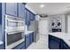 Kitchen features blue cabinetry, stainless steel appliances, and white countertops at 10201 Los Padres Pl, Las Vegas, NV 89134