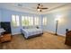 Relaxing bedroom with light blue walls, a comfy bed, and ample natural light at 10718 Del Rudini St, Las Vegas, NV 89141