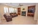 Spacious living room featuring a fireplace, built-in shelving, and tile flooring at 10718 Del Rudini St, Las Vegas, NV 89141