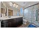 Well-lit bathroom featuring modern vanity, decorative mirror, and nautical-themed shower curtain at 11290 Hazel Rock St, Las Vegas, NV 89179