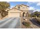 Two-story home with a beige exterior, arched entryway, and well-manicured front yard at 11290 Hazel Rock St, Las Vegas, NV 89179