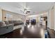 Expansive living room with hardwood floors, neutral paint, a ceiling fan, and a view of the dining area at 11290 Hazel Rock St, Las Vegas, NV 89179