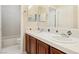 Bathroom featuring a double vanity with white countertop, dark wood cabinets, and a shower and tub at 12 Oro Valley Dr, Henderson, NV 89052