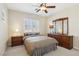 Comfortable bedroom with a queen bed, wood dresser, and ceiling fan at 12 Oro Valley Dr, Henderson, NV 89052