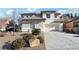 Two-story house with beige exterior, landscaped yard, and a two-car garage at 12 Oro Valley Dr, Henderson, NV 89052