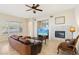 Living room with leather sofa, fireplace, and large windows at 12 Oro Valley Dr, Henderson, NV 89052