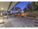 Covered back patio with concrete floor surrounded by mature trees and landscaping at 1202 S Rancho Dr, Las Vegas, NV 89102