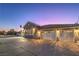 A well-lit home with an attached two-car garage and a spacious driveway at twilight at 1202 S Rancho Dr, Las Vegas, NV 89102