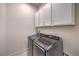 Modern laundry room with front load washer and dryer, and bright white cabinets for storage at 1202 S Rancho Dr, Las Vegas, NV 89102