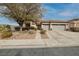 Single-story house with gray double garage doors and desert landscaping at 1592 Bamboo Bay Dr, Henderson, NV 89012