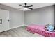 Cozy bedroom with gray walls, wood-look flooring, and ceiling fan at 1906 Palora Ave, Las Vegas, NV 89169