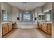 Bright bathroom featuring a soaking tub, dual vanities, and tiled floors at 2064 Poetry Ave, Henderson, NV 89052