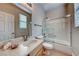 Bathroom featuring a glass enclosed shower/tub, vanity with mirror and natural light from window at 2064 Poetry Ave, Henderson, NV 89052