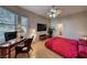 Bedroom featuring a wood floor, red bedspread, desk area and ceiling fan with light fixture at 2064 Poetry Ave, Henderson, NV 89052