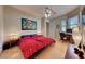 Bedroom featuring a wood floor, red bedspread, desk area and ceiling fan with light fixture at 2064 Poetry Ave, Henderson, NV 89052