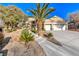 Beautiful home with well-manicured landscaping, a palm tree, and a three-car garage at 2064 Poetry Ave, Henderson, NV 89052