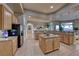 Spacious kitchen with island, granite counters, light wood cabinets, and stainless steel refrigerator at 2064 Poetry Ave, Henderson, NV 89052