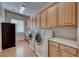 Laundry room featuring a washer, dryer, utility sink, storage cabinets and tile floor at 2064 Poetry Ave, Henderson, NV 89052