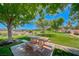 A stone picnic table and benches sit under a shade tree, offering a relaxing spot for outdoor dining at 2064 Poetry Ave, Henderson, NV 89052