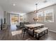 Spacious dining area with wood table, bench seating, and modern chandelier at 2242 Valdina St, Henderson, NV 89044