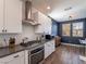 Modern kitchen with white cabinets, stainless steel range and vent hood at 2242 Valdina St, Henderson, NV 89044